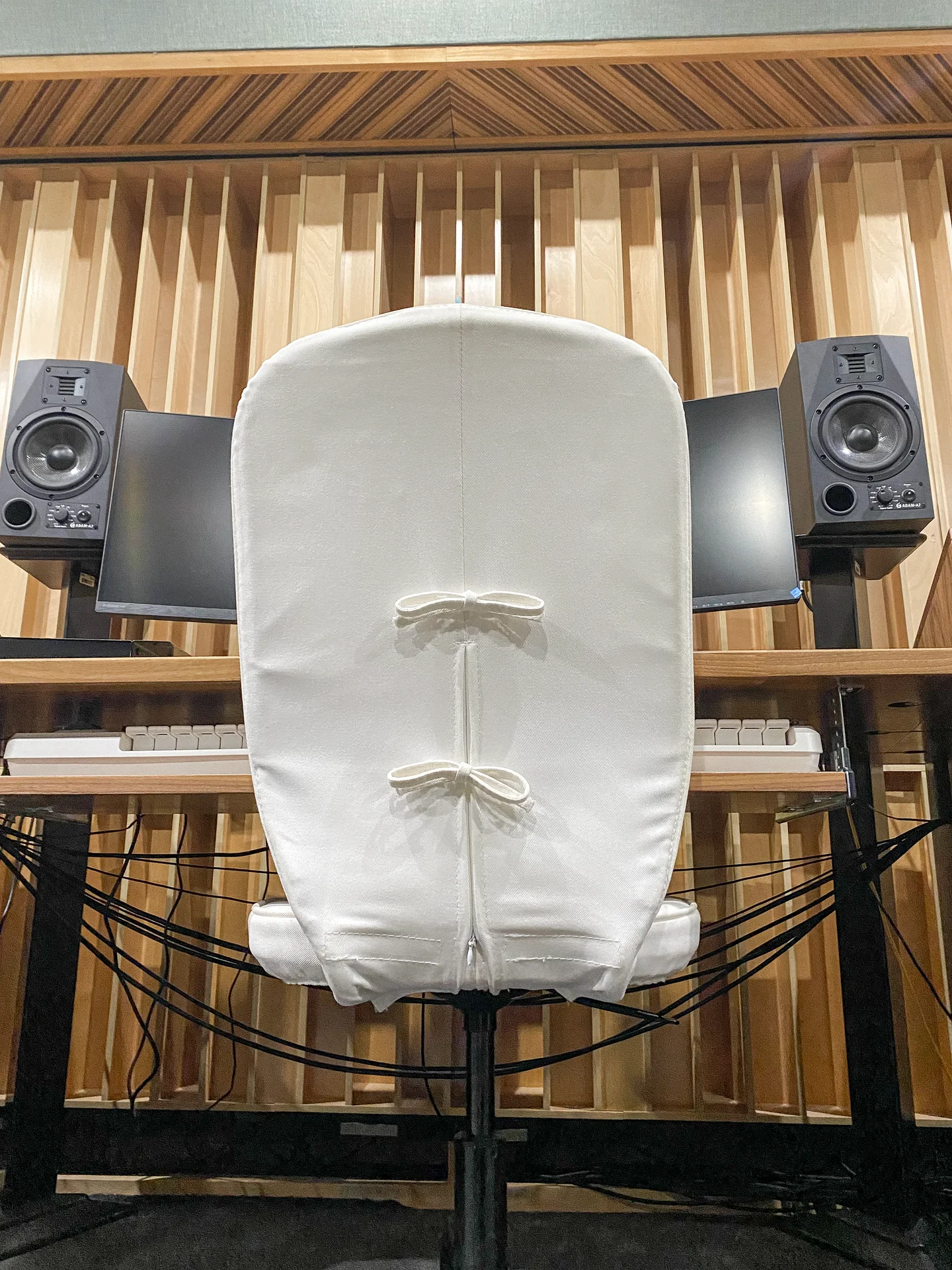 An empty chair waiting between two studio monitors